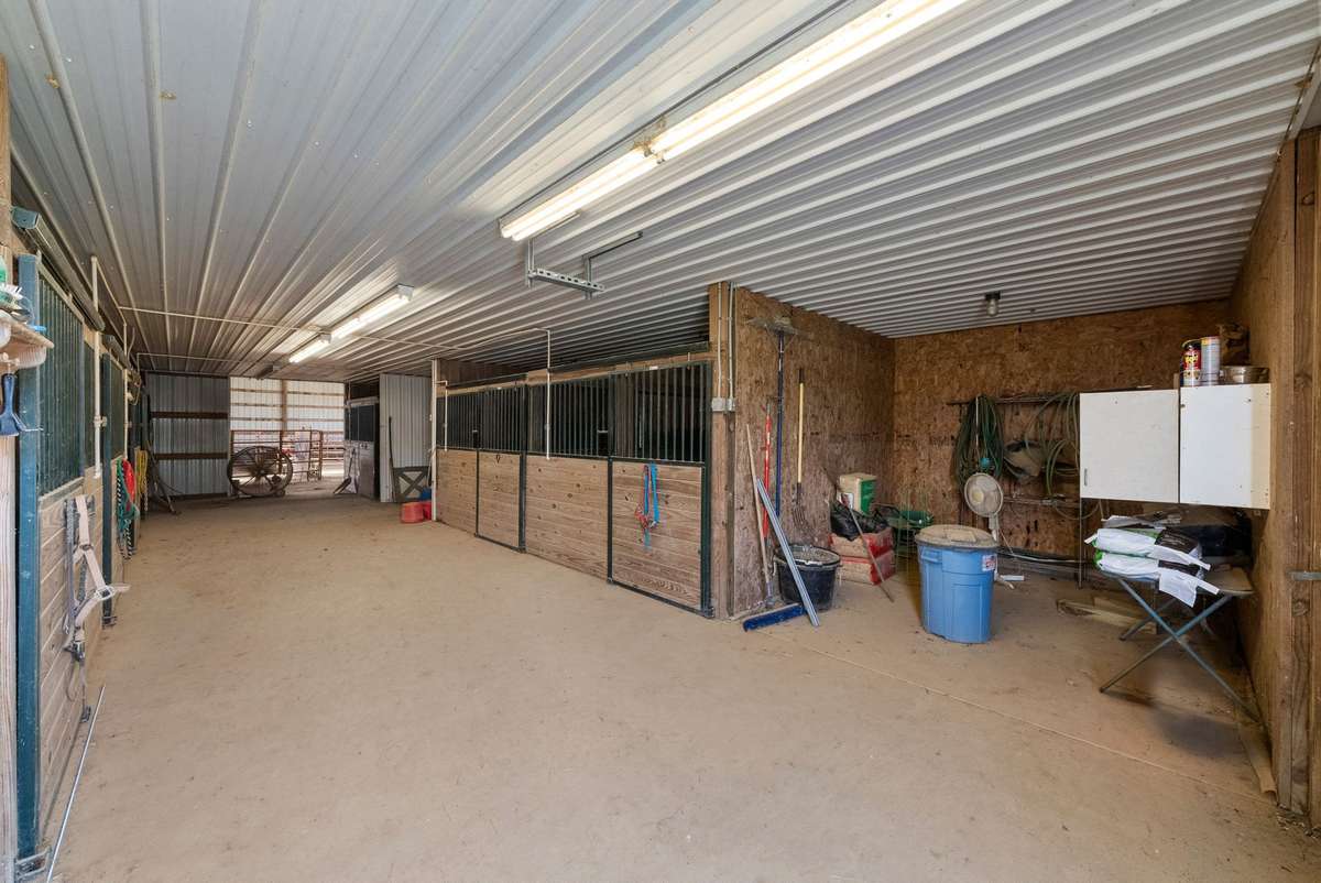 7-stall stables and tack room with concrete flooring.