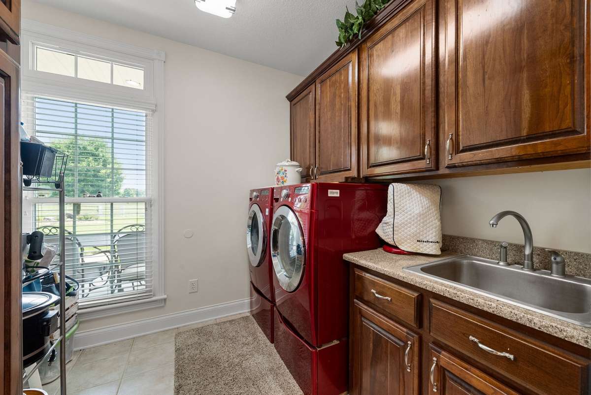 Huge laundry room with custom cabinetry, sink and a pantry