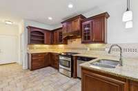 Kitchen island w/sink.  Gas Stove with a pot filler.  See open shelving cabinets for display.