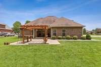Another view of the back of the house and large concrete patio w/pergola.