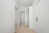 Walkway to the primary bedroom, laundry room and garage area, with built in storage!