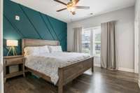 The owner's suite offers a gorgeous designer accent wall, Mohawk sustainable hardwoods, and a ceiling fan. The double window provides so much natural light!