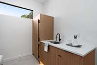 Wet bar with cabinet paneled refrigerator/freezer.