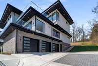 Owners parking pad and garage motor court with paver accents and ample radius for easy in and out of the oversized garage.
