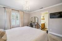 This bedroom has a Jack-n-Jill bath, crown molding and plantation shutters