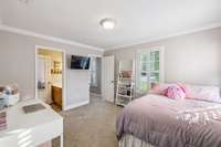 This bedroom has a Jack-n-Jill bath, plantation shutters, crown molding and a walk in closet