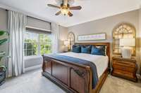 The primary bedroom on the first floor has been updated with paint, crown molding and ceiling fan