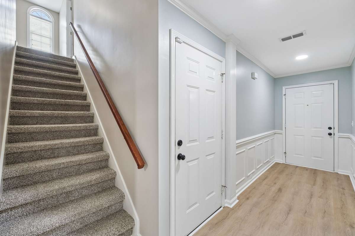 Stairway to upper level and entry door to garage