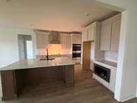 A cook's dream! Creamy white cabinets with soft close doors and drawers, a built in microwave and double ovens.  This kitchen has a very large island with lots of storage.