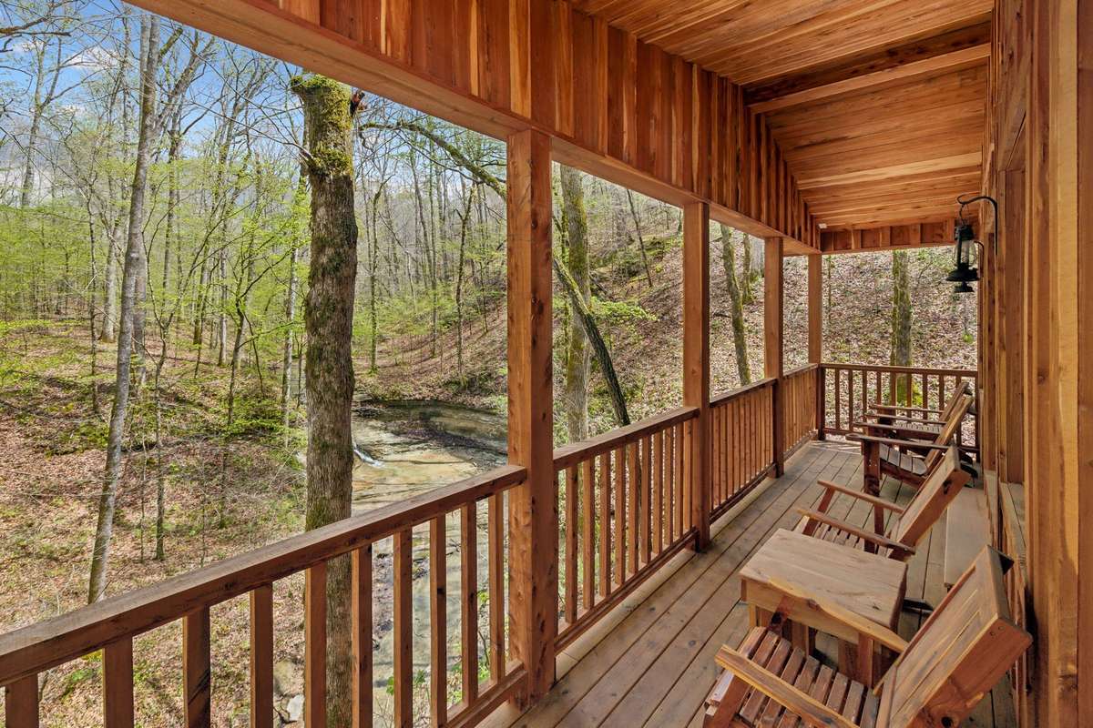 Covered patio facing woods and waterfall