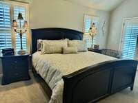 Primary Bedroom King Bedroom Suite that all stays! There are 2 Bedside Tables, Lamps, King Size Bed to include Comforter, Makeup Table, Chest with large TV on it. Also large Dog Crate and big comfy Lounge Chair in this Bedroom.