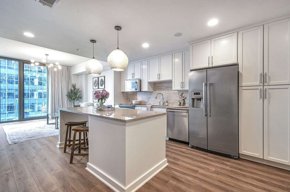 Kitchen has recessed lights, beautiful pendants, a large island, granite countertops and plenty of storage.