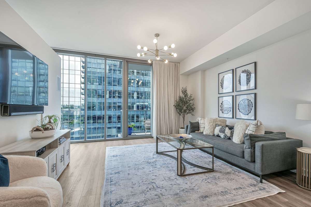 Sun kissed living room with floor to ceiling windows and ample space for furniture placement