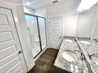 Double raised vanity, granite counters, tile shower and linen closet