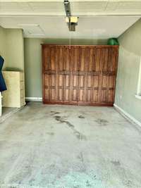 Spacious 1 Car Garage featuring Custom Cabinets and Storage Areas