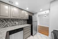 Remodeled kitchen with granite counters, stainless steel appliances, tile floors & backsplash, and a pantry.