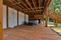 Covered deck on basement level with hot tub