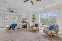 The primary suite offers a sunlit sitting area, en-suite bath, and walk-in closet.