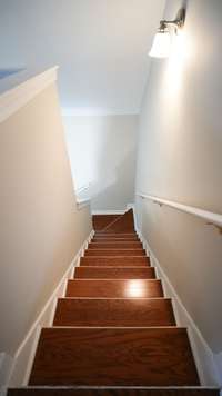 The architecturally interesting stairway features gleaming wood stair treads to the second level of the home.