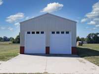 Attractive 2 bay detached garage with large overhead remote doors- oh, the possibilities!