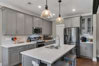 This kitchen features extensive solid surface counter space, a walk-in pantry, and ample room to finally host that dinner party.