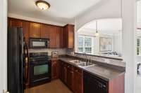 Kitchen with Tile Backsplash & Pantry. Artwork above the couch is virtually staged.