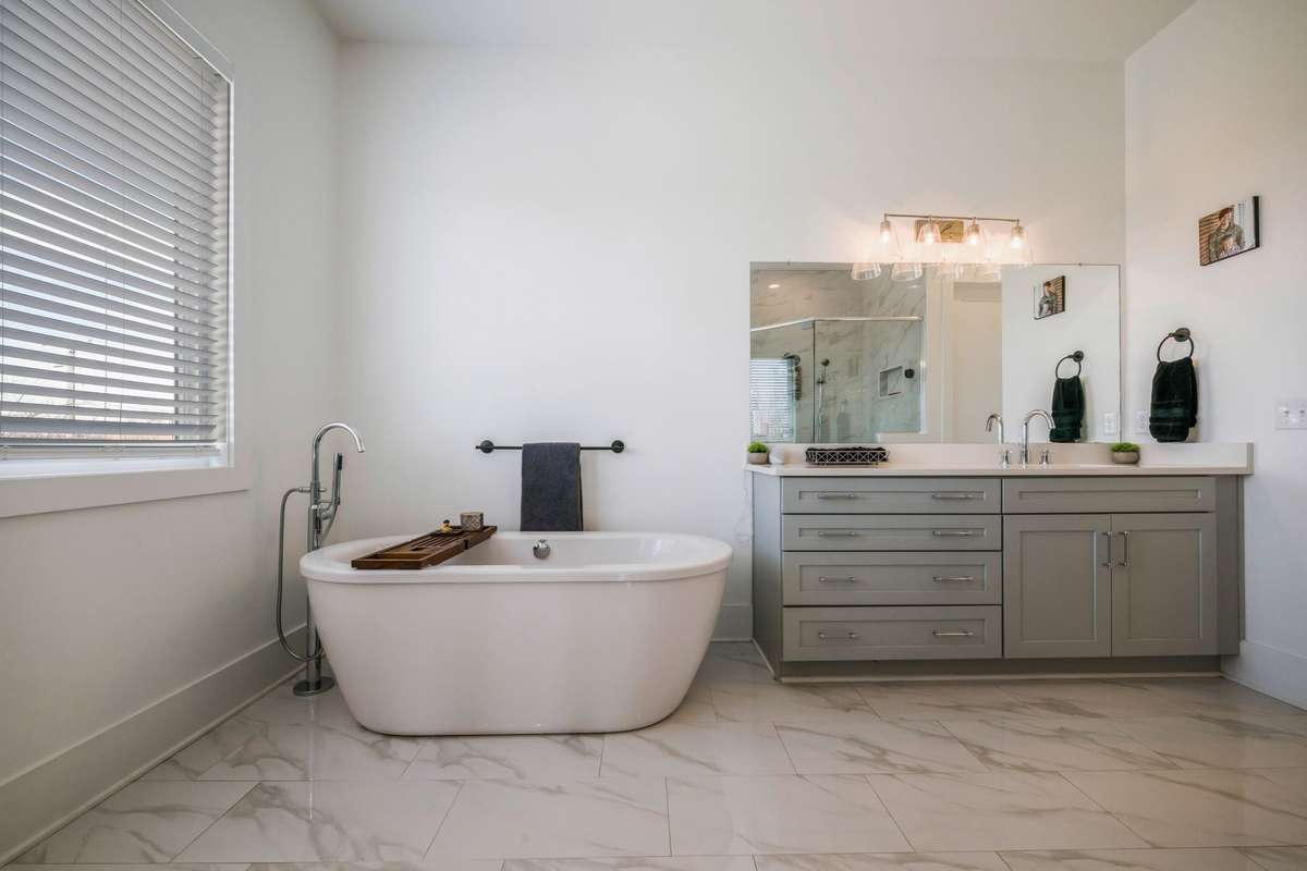 Partial view of the primary bathroom with walk-in shower and 2 vanities.