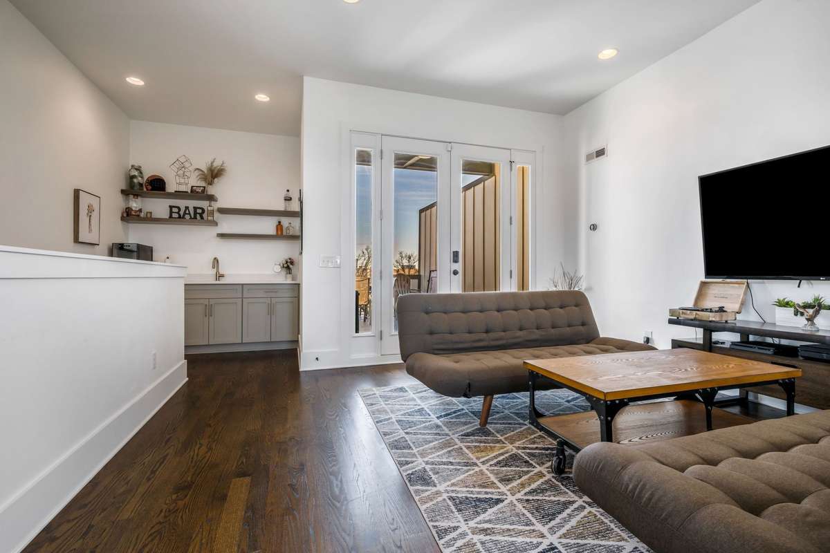3rd floor rec room is sure to be the party spot with a wet bar with wine fridge (remains) and French doors that open to rooftop deck #1 where you can be just a couple steps away from the grill on game day. Not pictured is a half bath on this level.