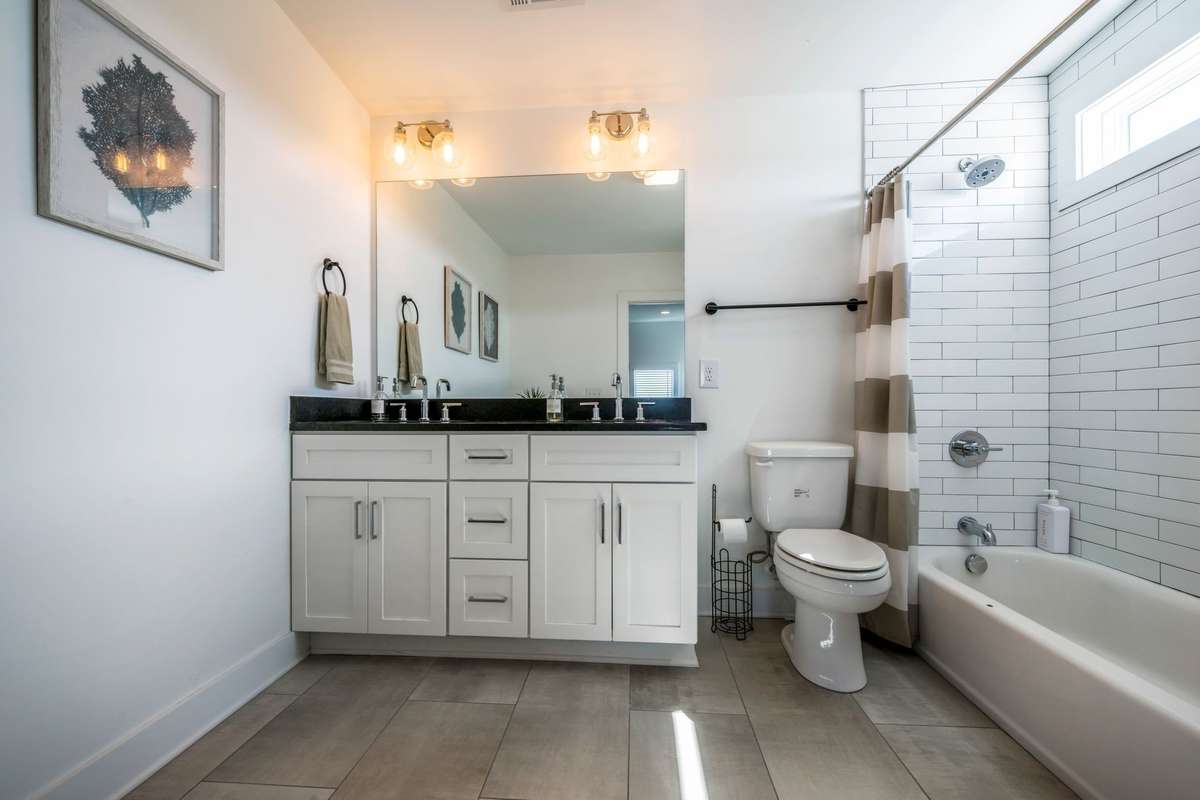 The full bath with dual vanity sink continues the design theme. Linen closet (not pictured) and more wall space if you need more storage.