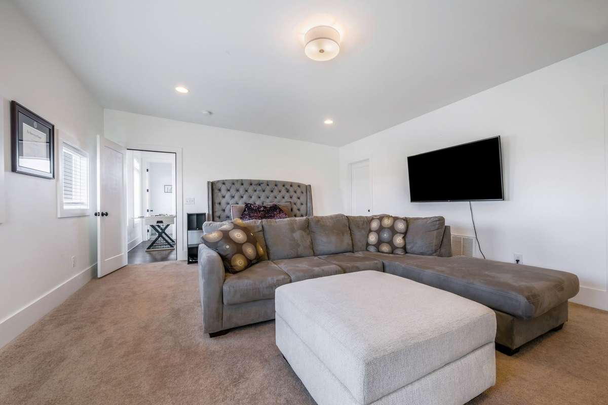 Bedroom #4:  3rd Fl 2nd primary suite & the ONLY room with carpet.  Remember, we have tenants who are gamers and odds are you won't need a sectional here but it does make the pt...this is spacious--there's even a desk too! Large walk-in closet.