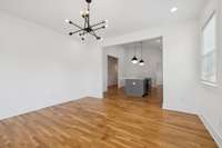 This photo features the living room that is open to the kitchen.