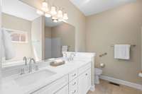 The primary bathroom boasts gorgeous, new quartz countertops, new sinks, new faucets and a new frameless shower door.