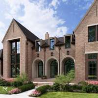 The front elevation features three recessed half-round doors, creating a distinctive and welcoming entry to the home.