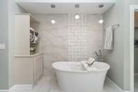 The primary bathroom suite is a true retreat, where luxury meets tranquility. Featuring a freestanding soaker tub, it offers the ideal space to relax and unwind after a long day. Not pictured is the heated-seat toilet with programmable settings!