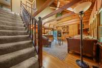 The open landing overlooks the great room, showcasing the vaulted ceiling and rustic wood details, adding to the home’s spacious and inviting cabin-like feel.