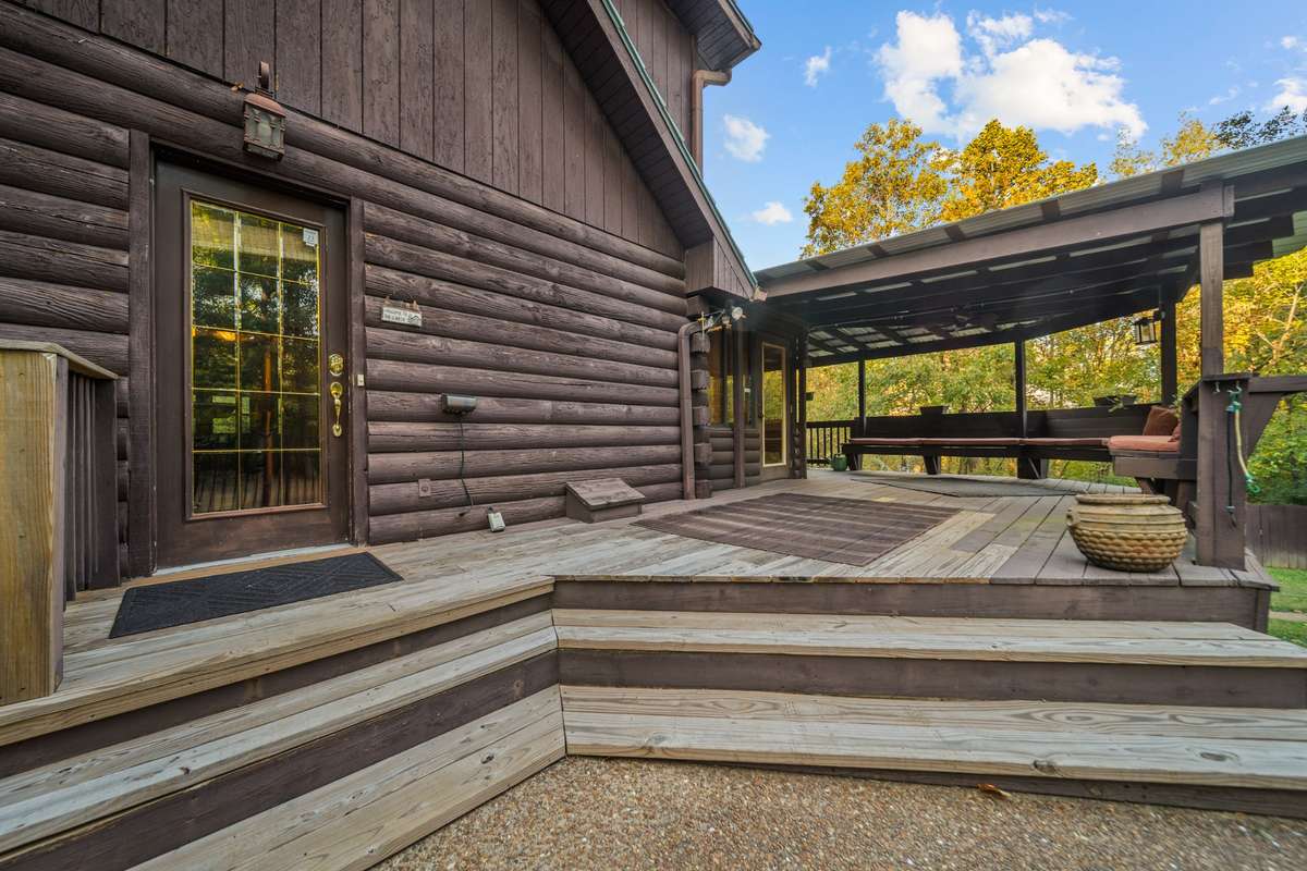 Enter your retreat-style home from the side! Covered deck for entertaining, gas grill-ready, and breathtaking pool and wooded views—luxury meets comfort.