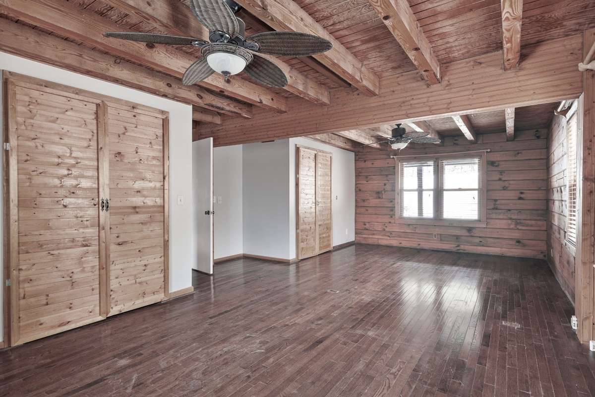 Primary bedroom with king-size bed space, sitting/work area, and gorgeous hardwood floors.