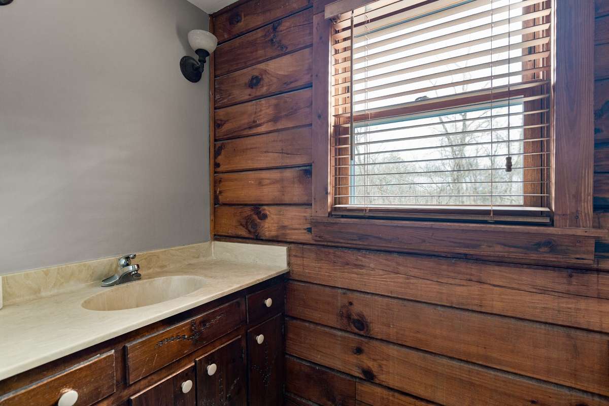 Primary bath located right next to the primary bedroom for convenience, featuring a full tub/shower with updated showerhead, newer upscale toilet, and fresh paint.