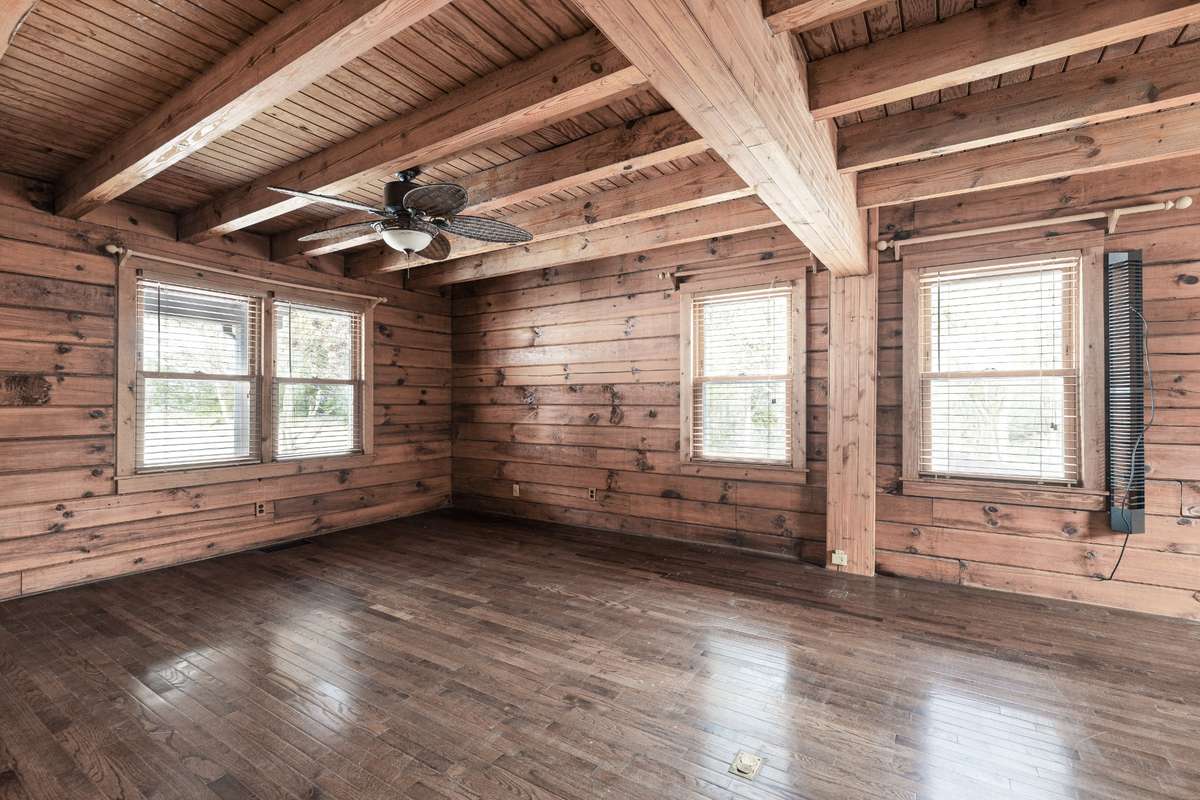 Another view of the primary suite showcasing its spacious layout, abundant natural light, and warm, cozy cabin-style features.