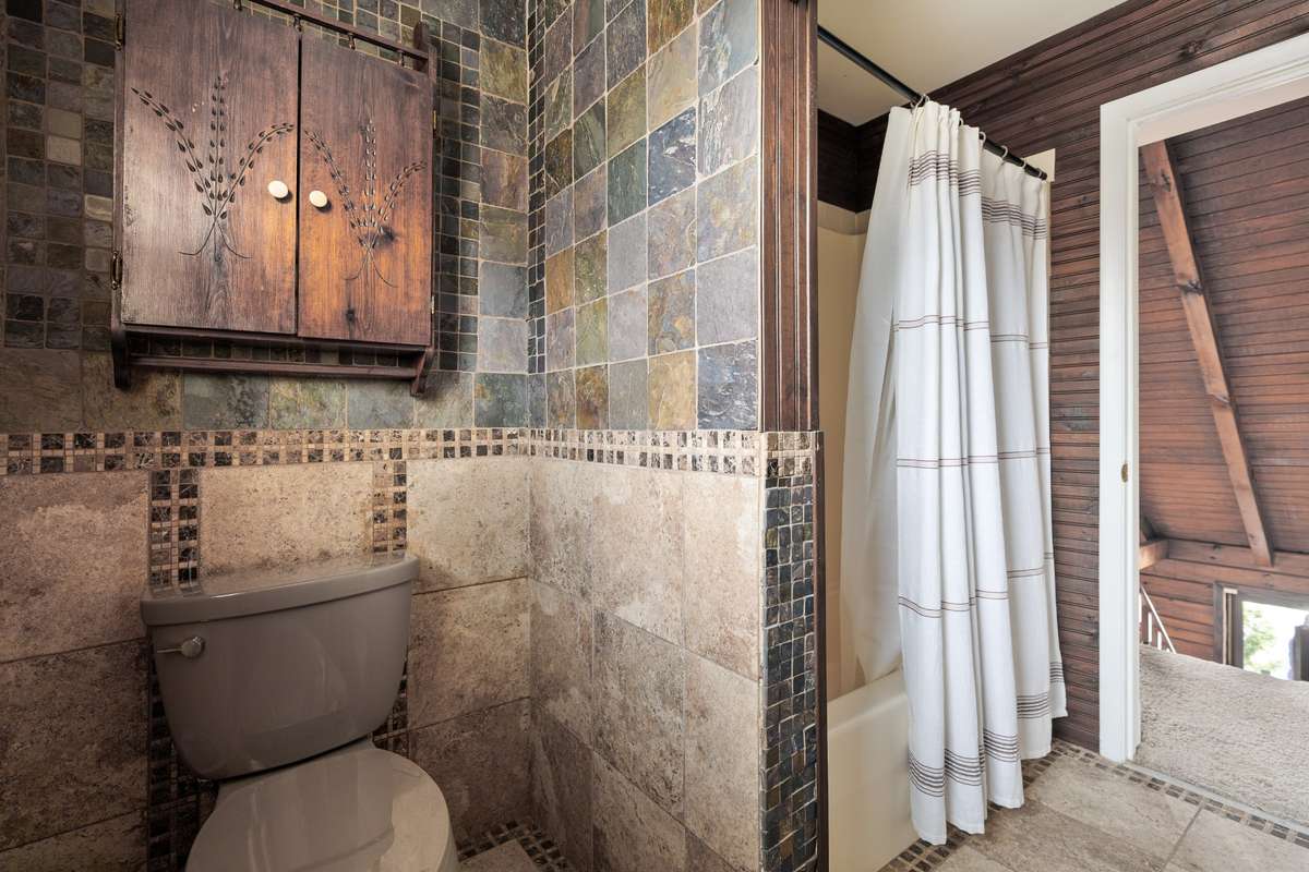 The second-level bathroom features stunning tile walls and flooring, truly a must-see!