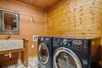 Laundry room with a generous layout, stone sink, and room for a tanning bed or added shelving. (Washer, dryer, and refrigerator not included.)