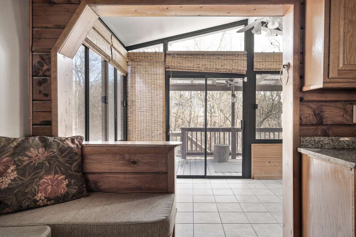 Entrance to the sunroom overlooking the backyard and pool, with two-way access to the back deck and side porch.