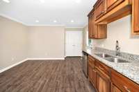 Kitchen- tile flooring, stainless steel appliances, granite countertops, wood cabinetry, eat-in kitchen/dining area, crown molding, recessed lighting
