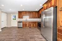 Kitchen- tile flooring, stainless steel appliances, granite countertops, wood cabinetry, eat-in kitchen/dining area, crown molding, recessed lighting