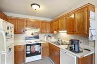 Cozy kitchen with a good number of cabinets and counter space. All appliances will remain.