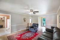 The living area is spacious with some decorative wood trimming. Note the foyer and in the left corner, the doorway leads to the primary bedroom.