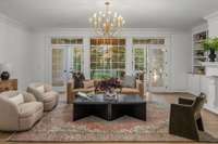 Living room leading to covered porch and back yard