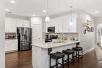 The kitchen is large for a home this size! It has new countertops and a new dishwasher, microwave, and stove in the last 12 months. There is plentiful counter space and a bar seating area. There is also plentiful light!