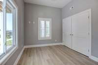 Second bedroom downstairs with large closet built in black out shades and plantation shutters