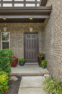 The landscaped entryway leads us to the front porch that is covered and nice sized.